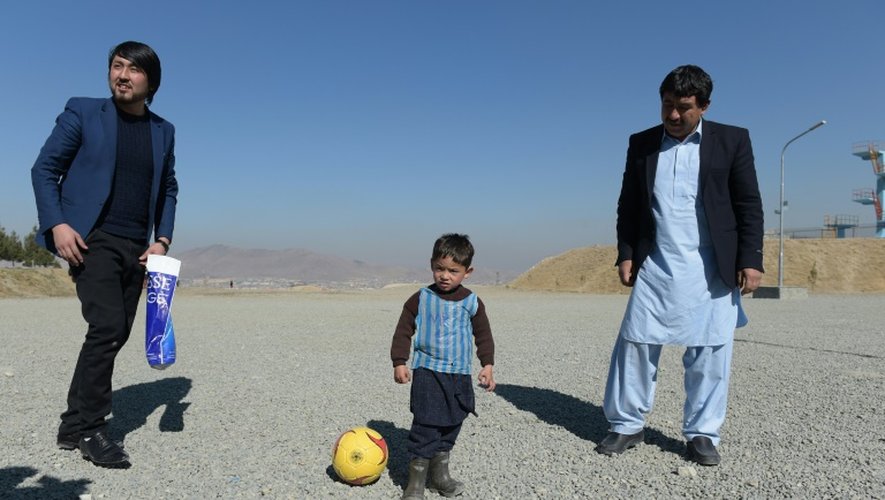 Muhammad Arif Ahmadi (à droite), 44 ans, regarde son fils Murtaza Ahmadi, jouer au football à Kaboul le 1er février 2016. Le jeune garçon, fan de Lionel Messi, espère rencontrer bientôt son idole du Barça