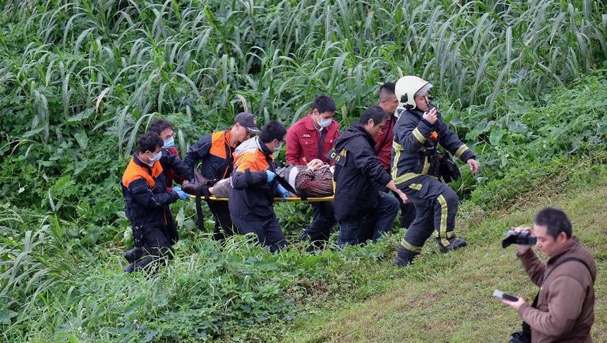 Des secouristes évacuent un passager blessé dans le crash d'un avion de la TransAsia Airways, le 4 février 2015 à Taipei