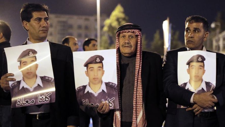 Des proches du pilote jordanien Maaz al-Kassasbeh  brûlé vif par le groupe EI montrent son portait à Amman le 27 janvier 2015