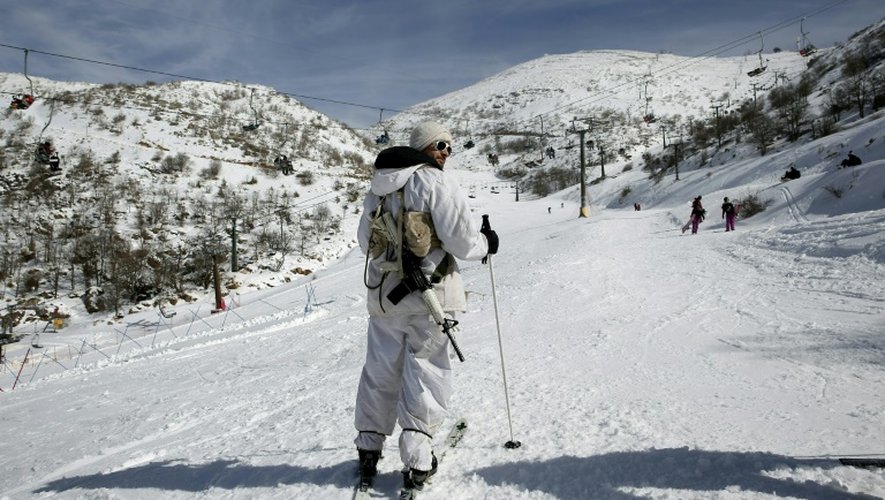 Un militaire israélien observe les skieurs sur une piste du mont Hermon, sur le Golan occupé par l'Etat hébreu, le 21 janvier 2016