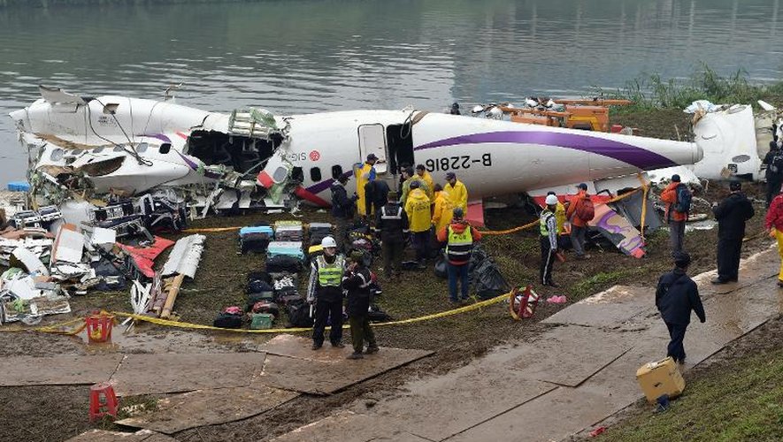 Des équipes de secours autour du fuselage de l'ATR 72-600 de la TransAsia sorti de l'eau, le 5 février 2015 à Taipei