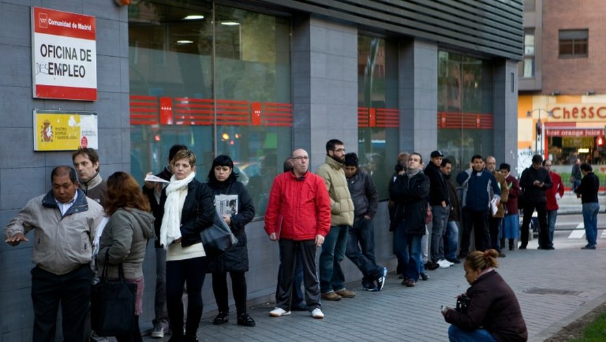 Des demandeurs d'emploi patientent devant une agence pour l'emploi à Madrid le 2 décembre 2014