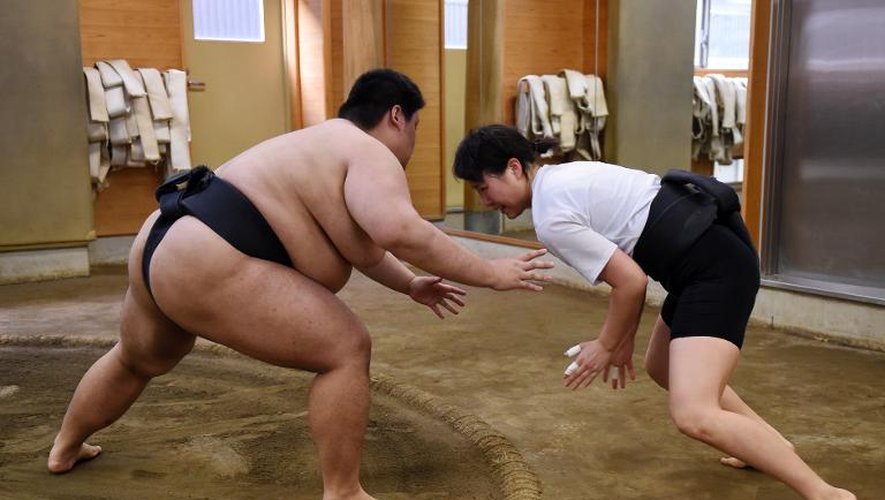 Une Japonaise s'entraîne au sumo contre un adversaire masculin, le 25 janvier 2015 à Tokyo