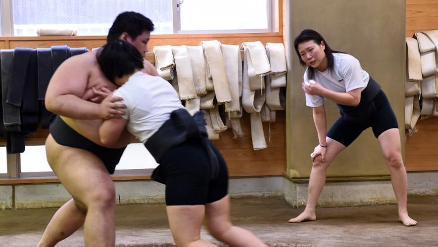 Deux Japonaises s'entraînent au sumo contre un adversaire masculin, le 25 janvier 2015 à Tokyo