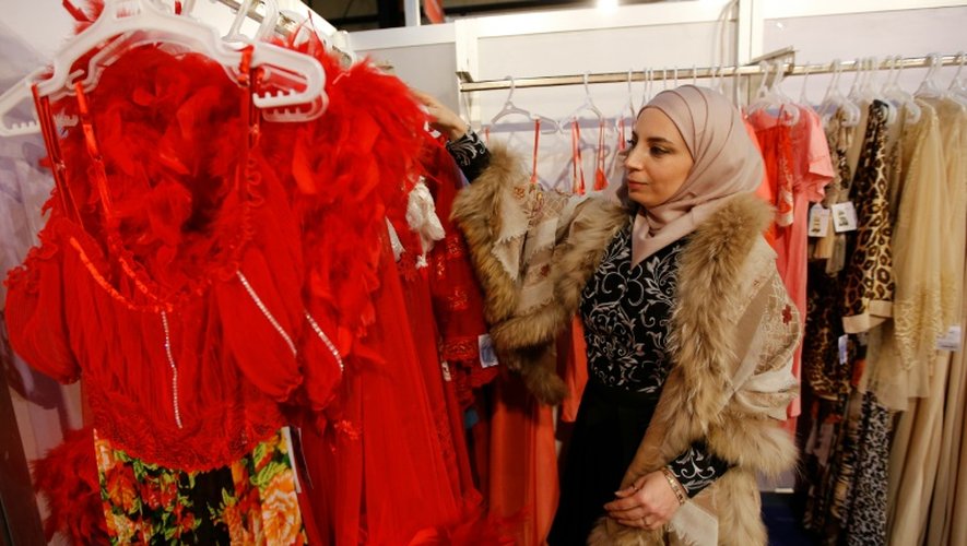 Une femme regarde des robes faites à partir de textile syrien, lors d'une exposition à Beyrouth le 20 janvier 2016