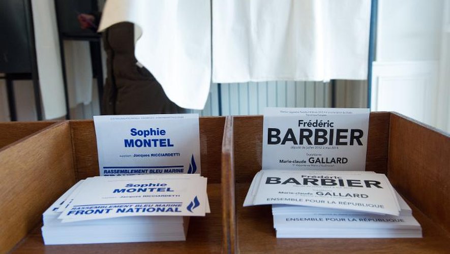 Les bulletins de vote des candidats FN Sophie Monteil, et PS Frédéric Barbier, empilés devant l'isoloir le 8 février 2015 dans un bureau de vote de Pont-de-Roide