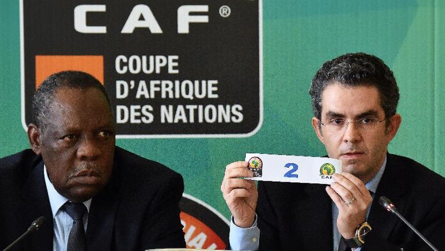 Le secrétaire général de la CAF Icham El Amrani (d) montre le numéro de la Guinée équatoriale gagnante du tirage au sort aux dépens du Mali pour disputer les quarts de finale de la CAN, le 29 janvier 2015 à Malabo