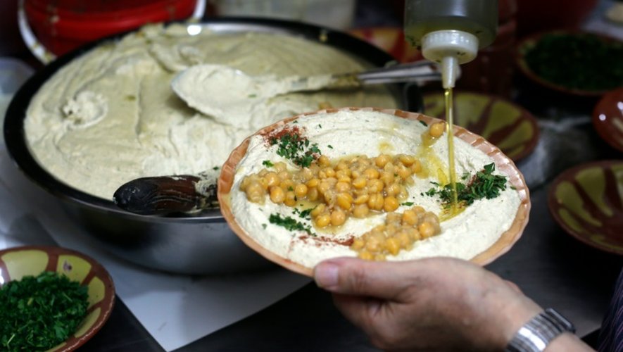 Un restaurateur palestinien prépare un plat de hoummous, purée froide à base de pois chiches, dans la vieille ville de Jérusalem, le 12 septembre 2015