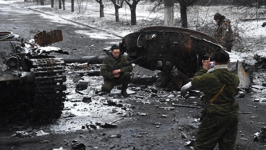 Des séparatistes prorusses se photographientà côté d'un char ukrainien détruit, le 9 février 2015 à Uglegorsk, près de Debaltseve, dans l'Est de l'Ukraine