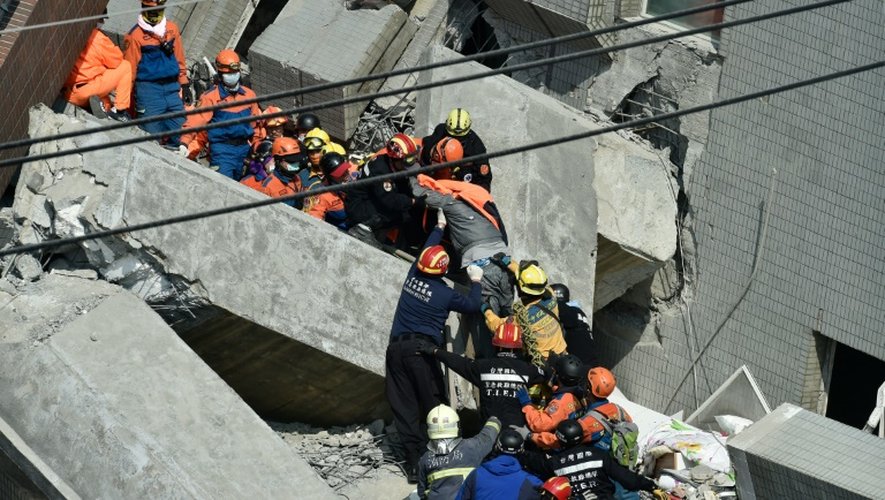 Des secouristes recherchent des survivants dans les décombres d'un immeuble le 7 février 2016, à Tainan, dans le sud de Taïwan, au lendemain d'un séisme de magnitude 6,4