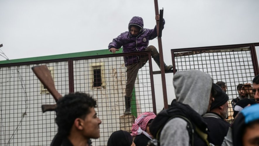 Un enfant parmi les réfugiés syriens escalade une clôture à Bab al-Salam, près de la frontière turque, le 6 février 2016