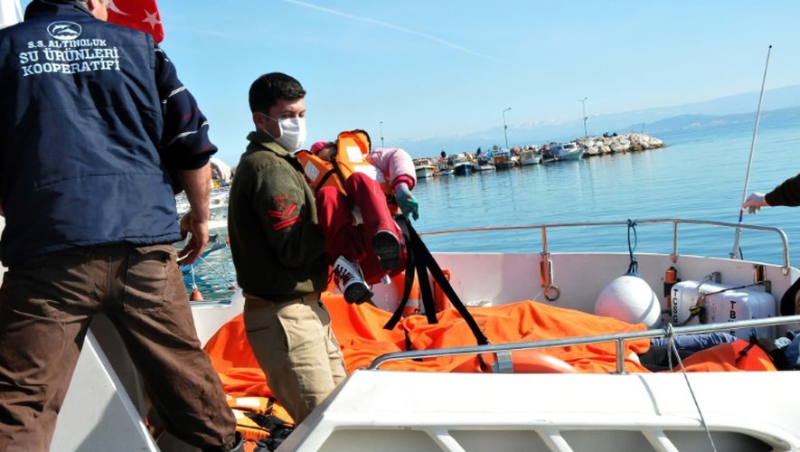 Des garde-côtes turcs portent le corps d'un enfant hors d'un bateau de secours le 8 février 2016 à Balikesir dans le district d'Altinoluk