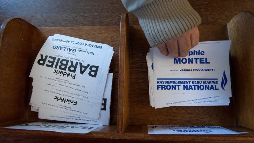 Une personne prend un bulletin de vote de la candidate du FN Sophie Montel, le 8 février 2015 à Pont de Roide