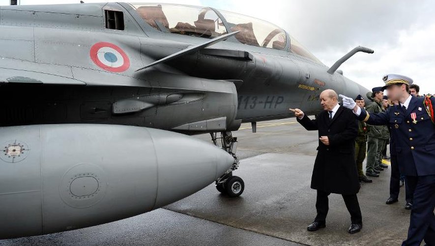Le ministre de la Défense, Jean-Yves Le Drian devant un rafale, le 12 avril 2013 sur la base aérienne d'Avord dans le centre de la France