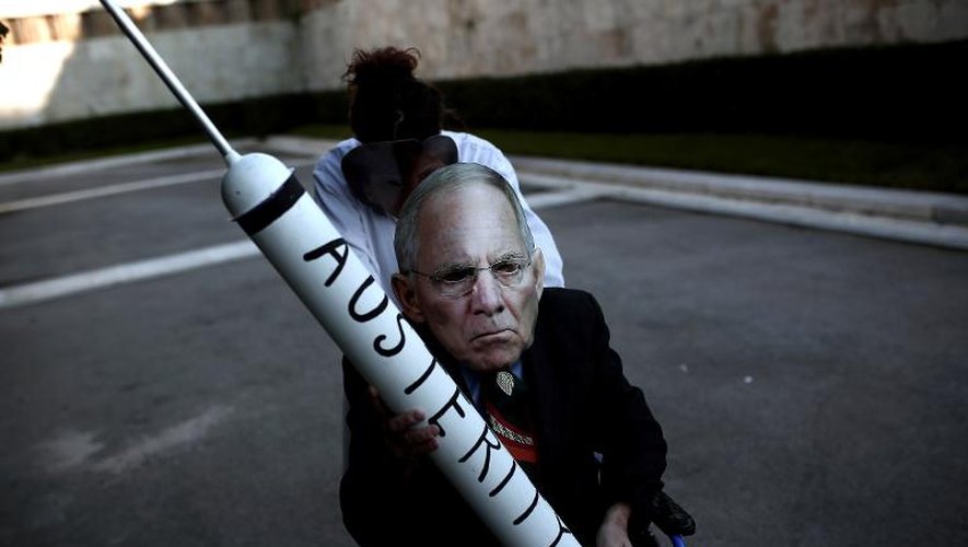 Un manifestant grec arborant un masque qui représente le ministre allemand des Finances Wolfgang Schaeuble, dénonce l'austérité lors d'un rassemblement devant le Parlement à Athènes le 15 février 2015