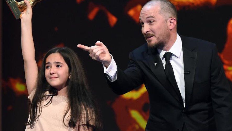 Le président de la Berlinale Darren Aronofsky et Hana Saeidi, le 14 février 2015 à Berlin, nièce du réalisateur iranien Jafar Panahi brandit le trophée récompensant le film de son oncle