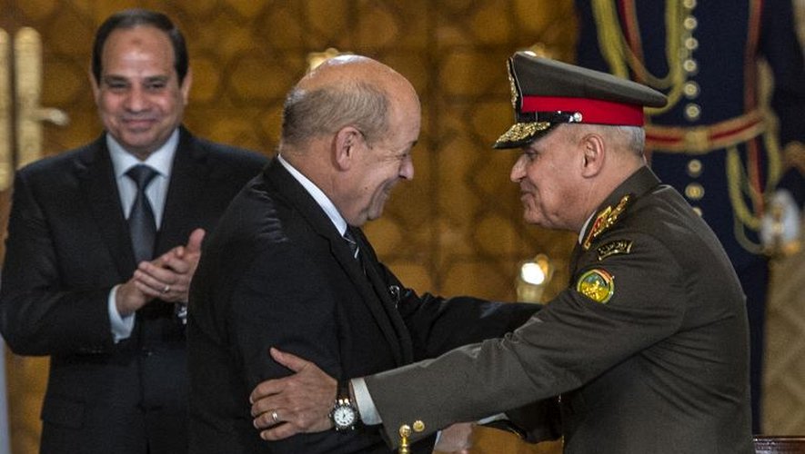 Le ministre français de la Défense Jean-Yves Le Drian (c) serre la main du général egyptien Sedki Sobhi (d), sous les yeux du président égyptien, Abdel Fattah al-Sissi, au Caire, le 16 février 2015