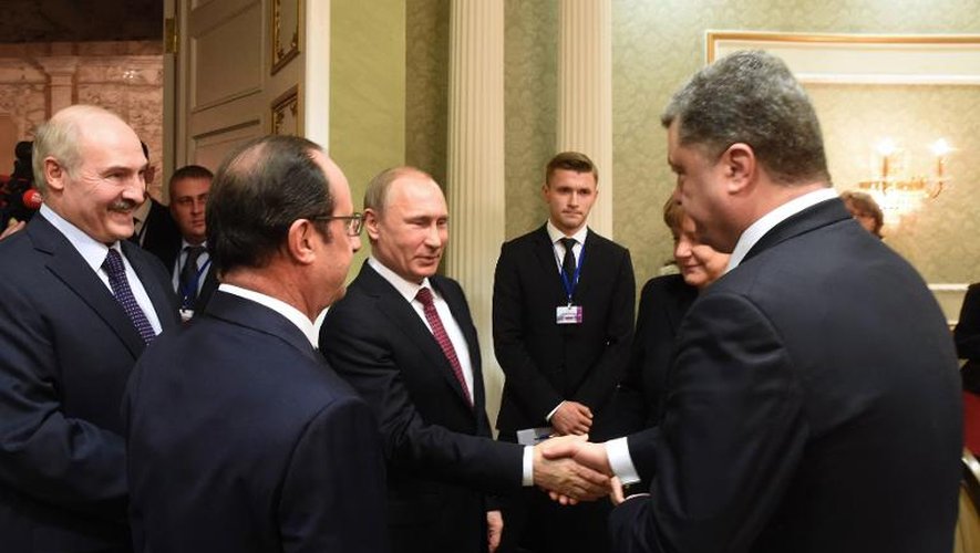 Poignée de mains entre le président russe Vladimir Poutine (c) et  le président ukrainien Petro Porochenko (d), le 11 février 2015 à Minsk
