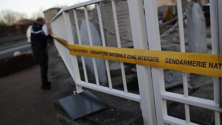 Un gendarme installe un cordon de sécurité après la profanation d'un cimetière à Tracy-sur-Mer (Calvados), le 18 février 2015