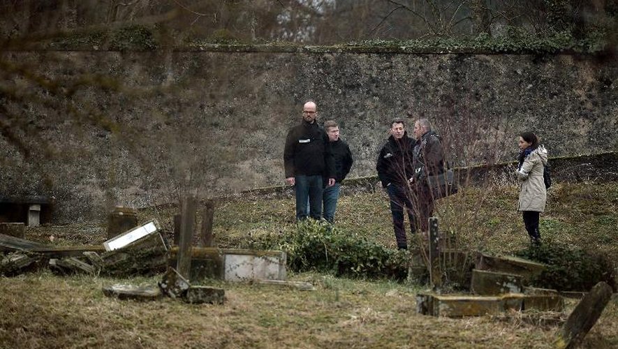 Des enquêteurs examinent le 16 février 2015 les tombes profanées du cimetière juif de Sarre-Union, dans le Bas-Rhin