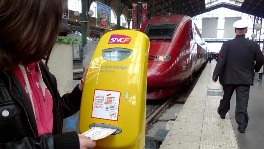 Une voyageuse composte son billet le 3 mars 2013 à la gare de Lille
