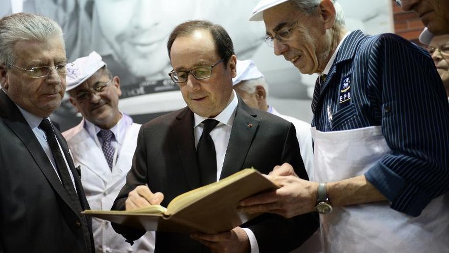 François Hollande écrit sur le livre d'or de la Fédération des bouchers le 21 janvier 2015 lors de sa visite au Salon de l'Agriculture à Paris