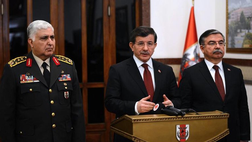 Le Premier ministre turc Ahmet Davutoglu entouré du chef de l'armée, le général Necdet Özel, et de son ministre de la Défense Ismet Yilmaz, lors d'une annonce aux médias le 22 février 2015 à Ankara