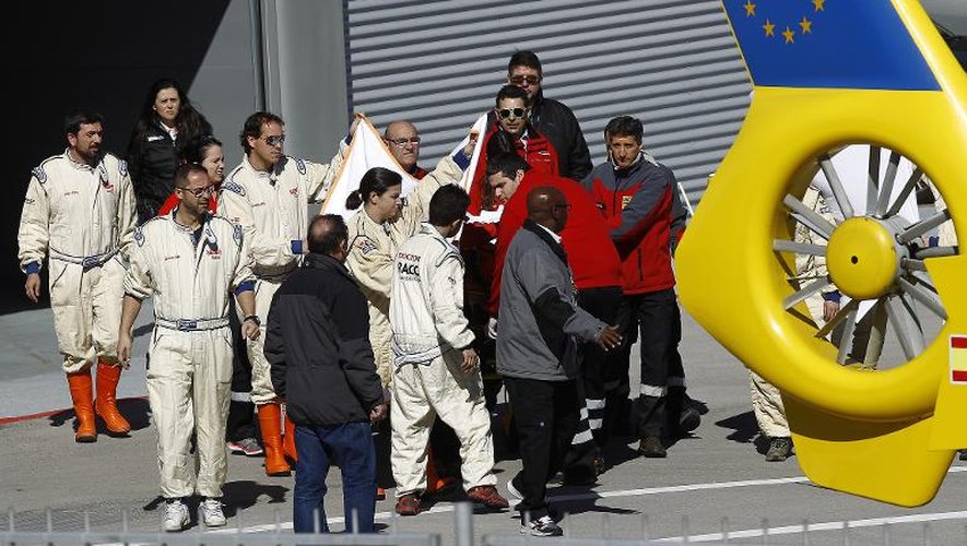 L'équipe McLaren entoure le pilote Fernando Alonso héliporté vers un hôpital après un accident sur le circuit de Catalogne, le 21 février 2015 à Montmelo
