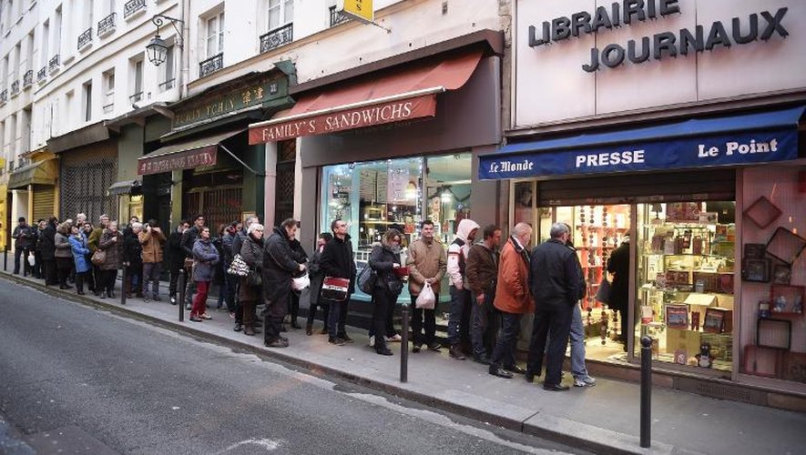 Des parisiens font la queue pour acheter le numéro des "survivants", le premier après la tuerie perpétrée par deux jihadistes, le 14 janvier 2015 à Paris