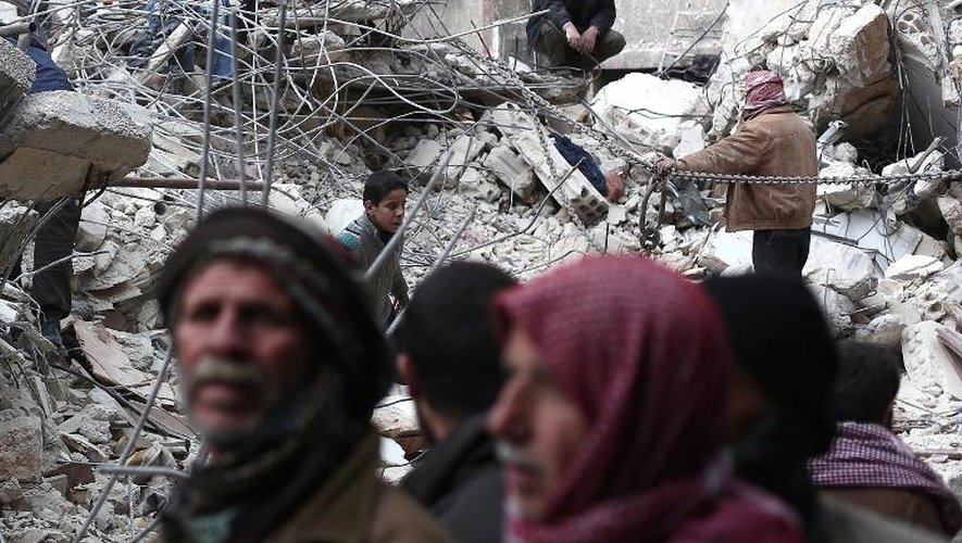 Des civils syriens cherchent des survivants dans les ruines d'un immeuble bombardé par l'armée régulière, à Douma, à l'est de Damas, le 9 février 2015