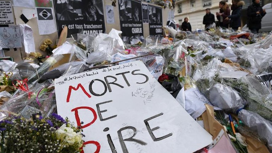 Des personnes rendent hommage aux victimes de l'attentat de Charlie Hebdo, le 15 février 2015 au siège du journal à Paris
