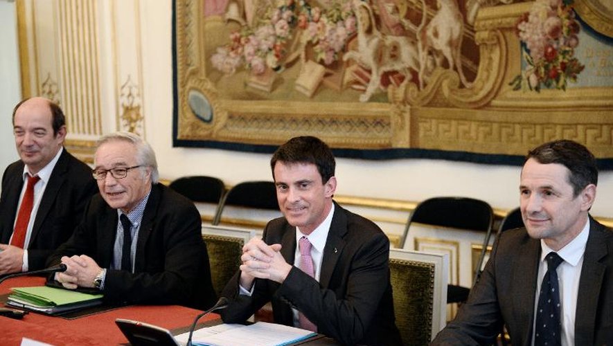 Le Premier ministre Manuel Valls (C), le ministre du travail Francois Rebsamen (g) et le secrétaire d'État à la Réforme de l'État Thierry Mandon (d)  le 25 février 2015 à Paris