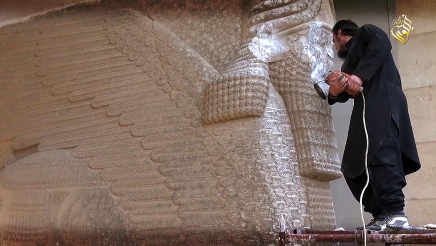 Des militants du groupe EI défigurent un taureau ailé assyrien sur un site archéologique de Mossoul, dans le nord de l'Irak