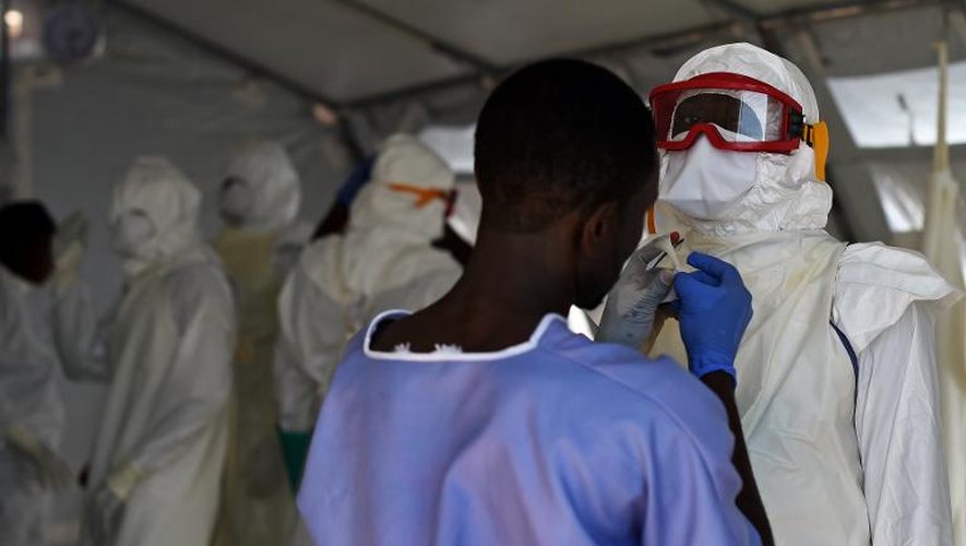 Des personnels médicaux enfilent leur tenue de protection contre Ebola, dans un centre de la Croix-Rouge à Kenema, en Sierra Leone, le 15 novembre 2014