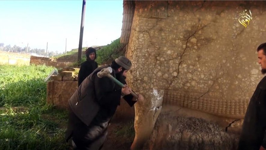 Image tirée d'une vidéo fournie par le groupe EI le 26 février 2015 montrant un militant détruisant une effigie de Lamassou, une divinité assyrienne, dans le nord du gouvernorat irakien de Ninive