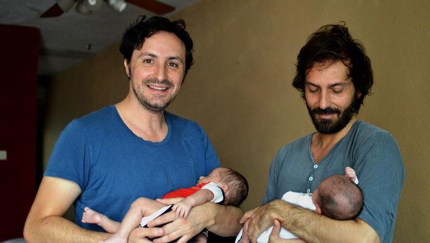 Un couple d'homosexuels espagnols José Antonio Fernandez (g) et Luis Delgado posent avec leurs bébés à Cancun au Mexique, le 18 février 2015