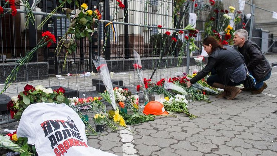 Un tee-shirt où il est inscrit "Poutine doit mourir" est posé devant l'ambassade russe à Kiev le 28 février parmi les fleurs en hommage à l'opposant russe Boris Nemtsov