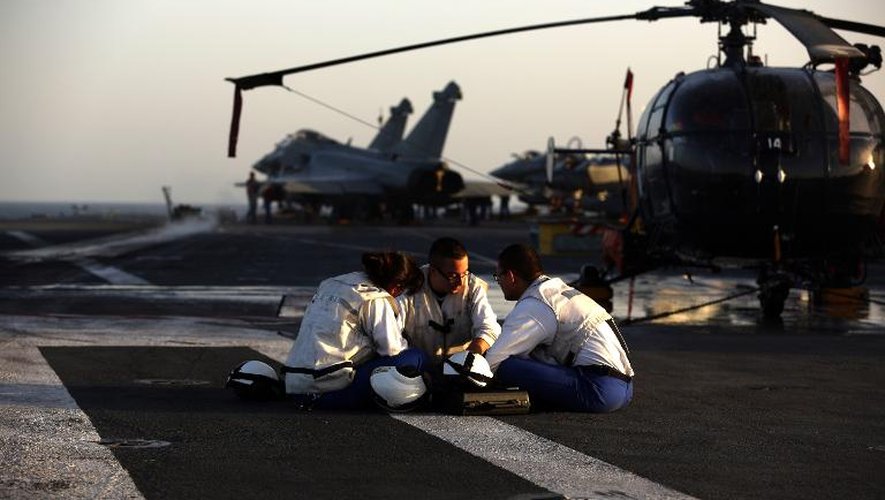 Des techniciens prennent une pause sur le pont du porte-avions Charles de Gaulle opérant dans le Golfe,  le 26 février 2015