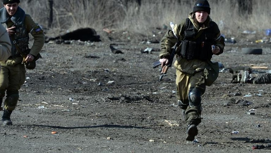 Des membres d'une équipe de démineurs rebelles prorusses courent pour s'abriter après avoir fait exploser des mines et engins piégés, dans la ville de Debaltseve en Ukraine, le 27 février 2015