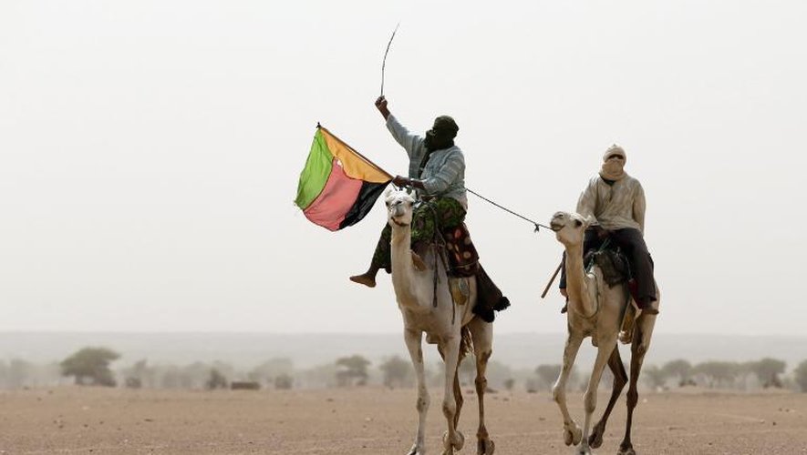 Un touareg brandit le drapeau du Mouvement national de libération de l'Azawad (MNLA) lors d'une manifestation à Kidal, dans le nord du Mali, le 28 juillet 2013