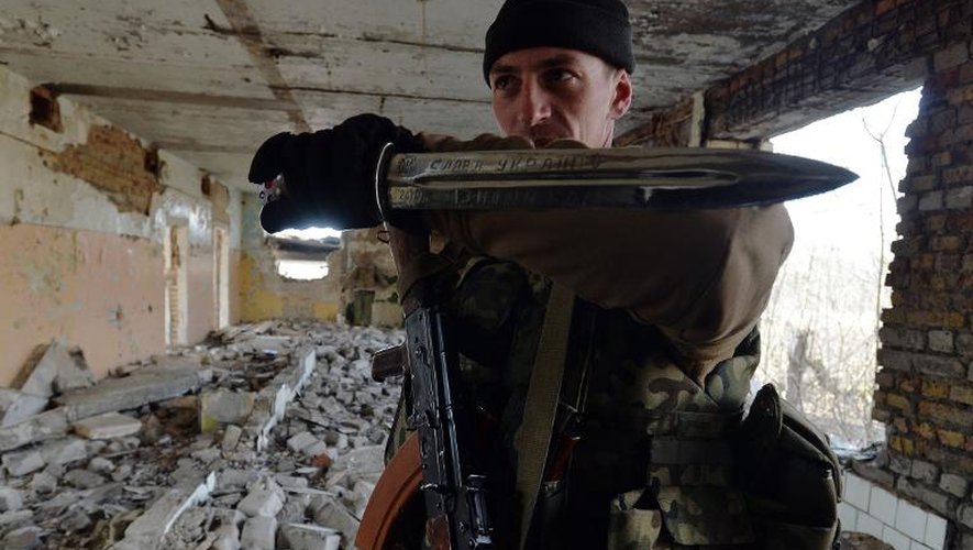 Un paramilitaire du bataillon d'Azov brandit un poignard où est inscrit "Gloire à l'Ukraine", lors d'un entraînement militaire près du port de Marioupol, le 27 février 2015