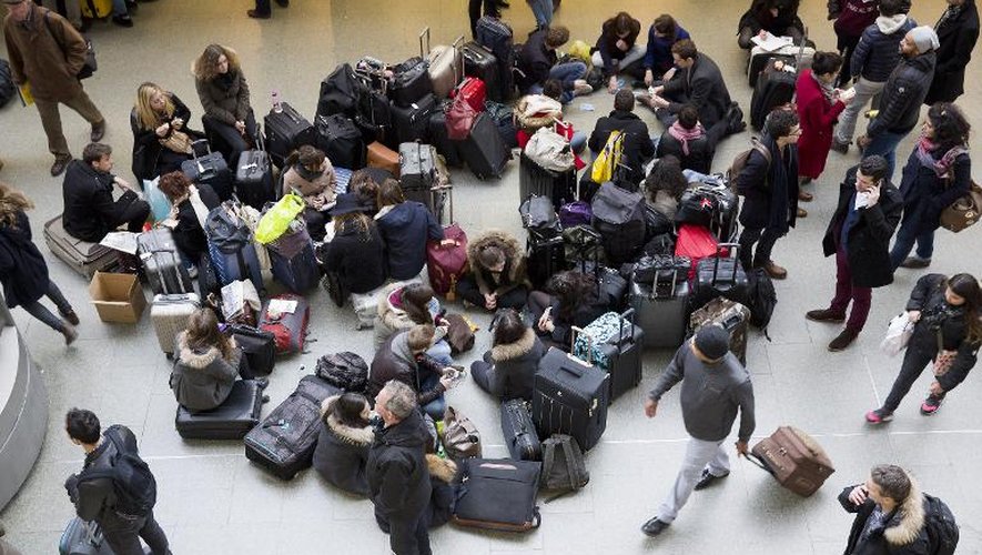 Les passagers attendent par terre à la gare de St Pancras à Londres le 2 mars 2015