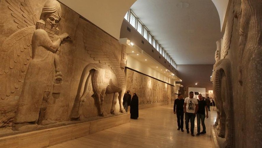 Des visiteurs devant un bas-relief assyrien dans le Musée national irakien de Bagdad, le 1er mars 2015