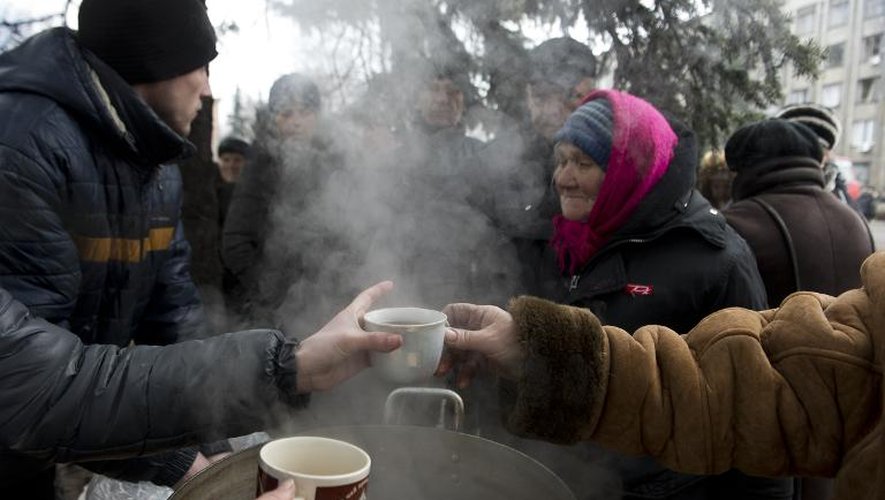Des personnes âgéess font la queue pour une tasse de thé chaud, le 2 mars 2015, lors d'une distribution place Lénine à Debaltseve, en Ukraine