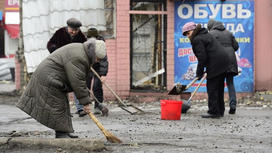 Des personnes balaient le 2 mars 2015 les gravats dans un coin de la place Lénine à Debaltseve, en Ukraine