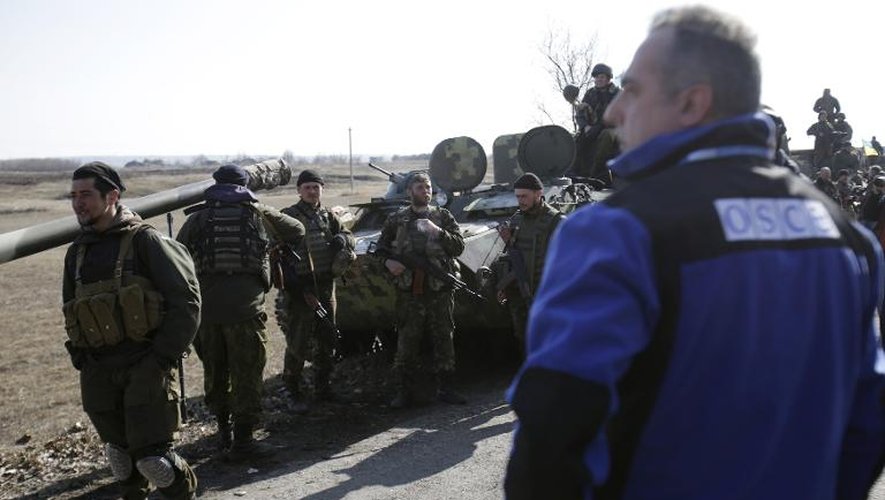 Un observateur de l'OSCE se tient au milieu de soldats ukrainiens le 27 février 2015 à Soledar, dans la région de Donetsk