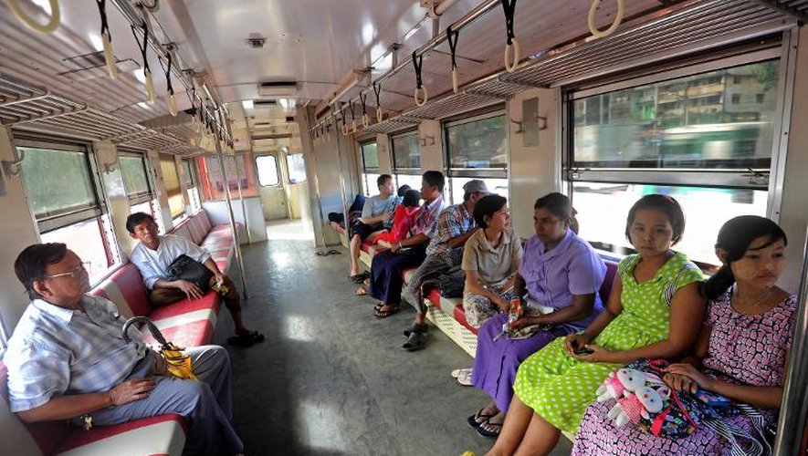 Des passagers assis dans un wagon du train qui fait le tour de Rangoun, le 15 décembre 2014