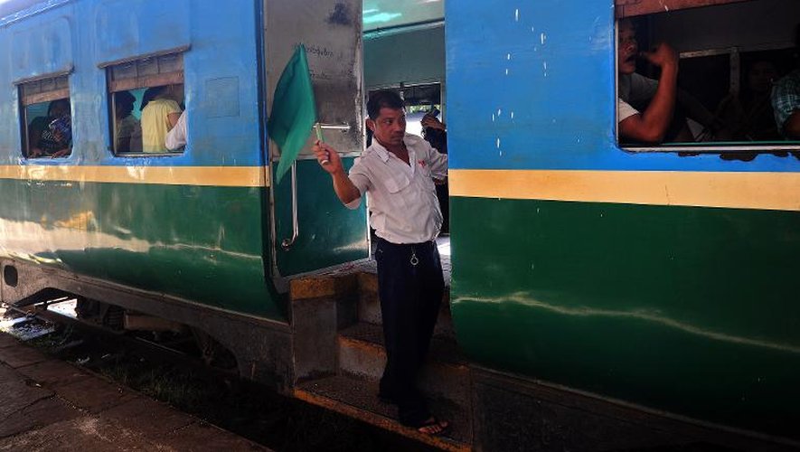 Un technicien fait le signe du départ alors que le train qui fait le tour de la ville de Rangoun s'apprête à démarrer le 8 décembre 2014