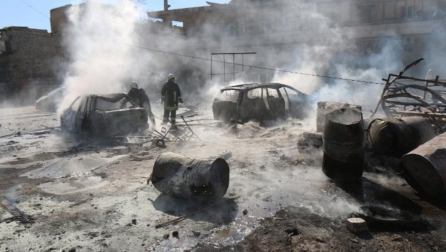 Des pompiers s'efforcent d'éteindre l'incendie provoqué par un baril d'explosifs largué selon une ONG par un hélicoptère du régime syrien contre un quartier rebelle de la ville d'Alep, tuant au moins 18 civils