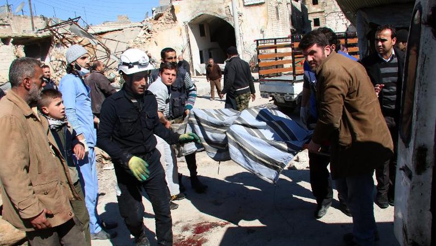 Des membres de la Défense civile évacuent le 5 mars 2015 un corps de la zone de la ville d'Alep où serait tombé un baril d'explosif lancé selon une ONG par un hélicoptère du régime syrien